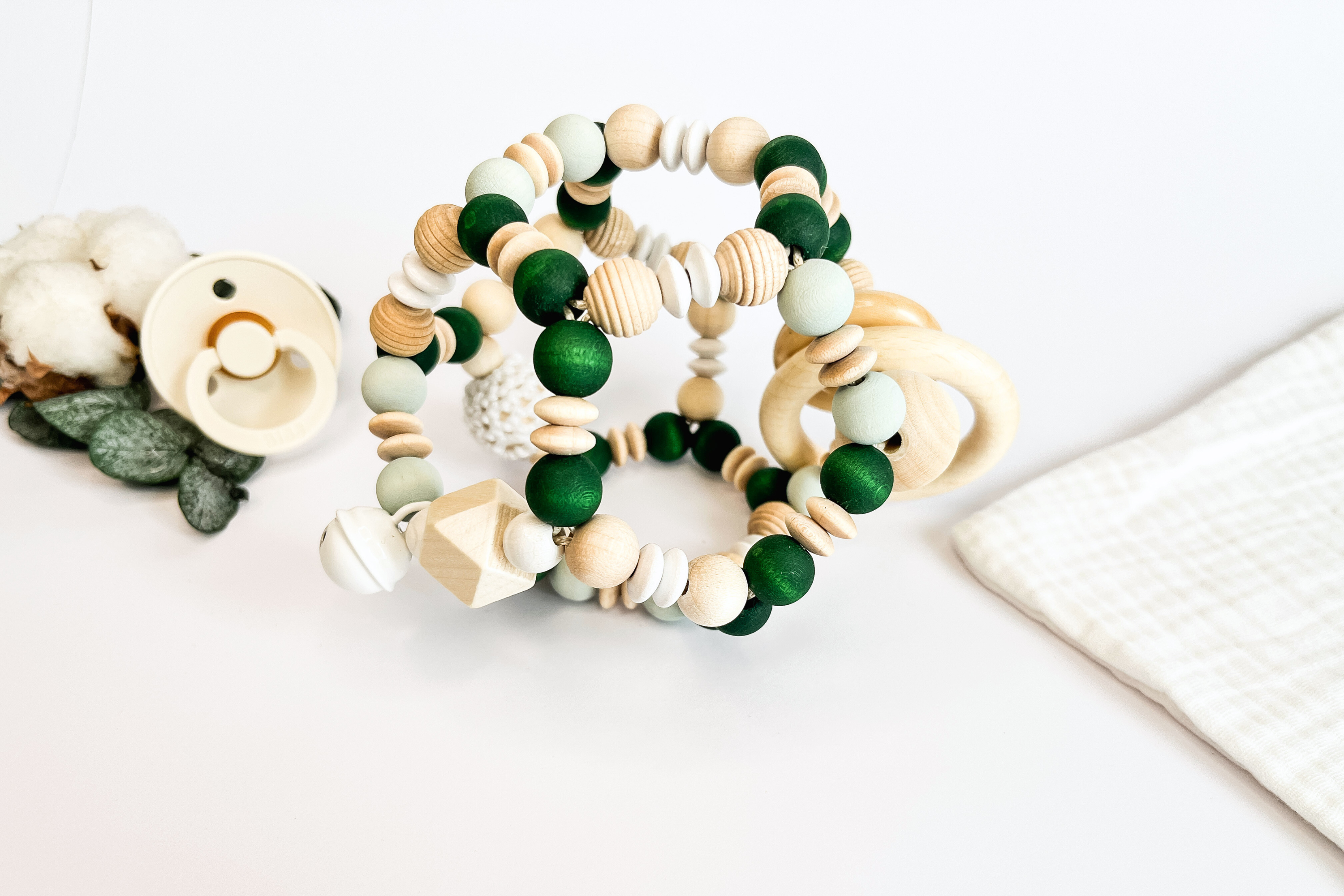 Handgemachter Greifball für Babys aus Holz, Silikon und Häkelperlen in natürlichen Farben – personalisierbar mit Namen, nachhaltiges Geschenk zur Geburt oder Taufe.