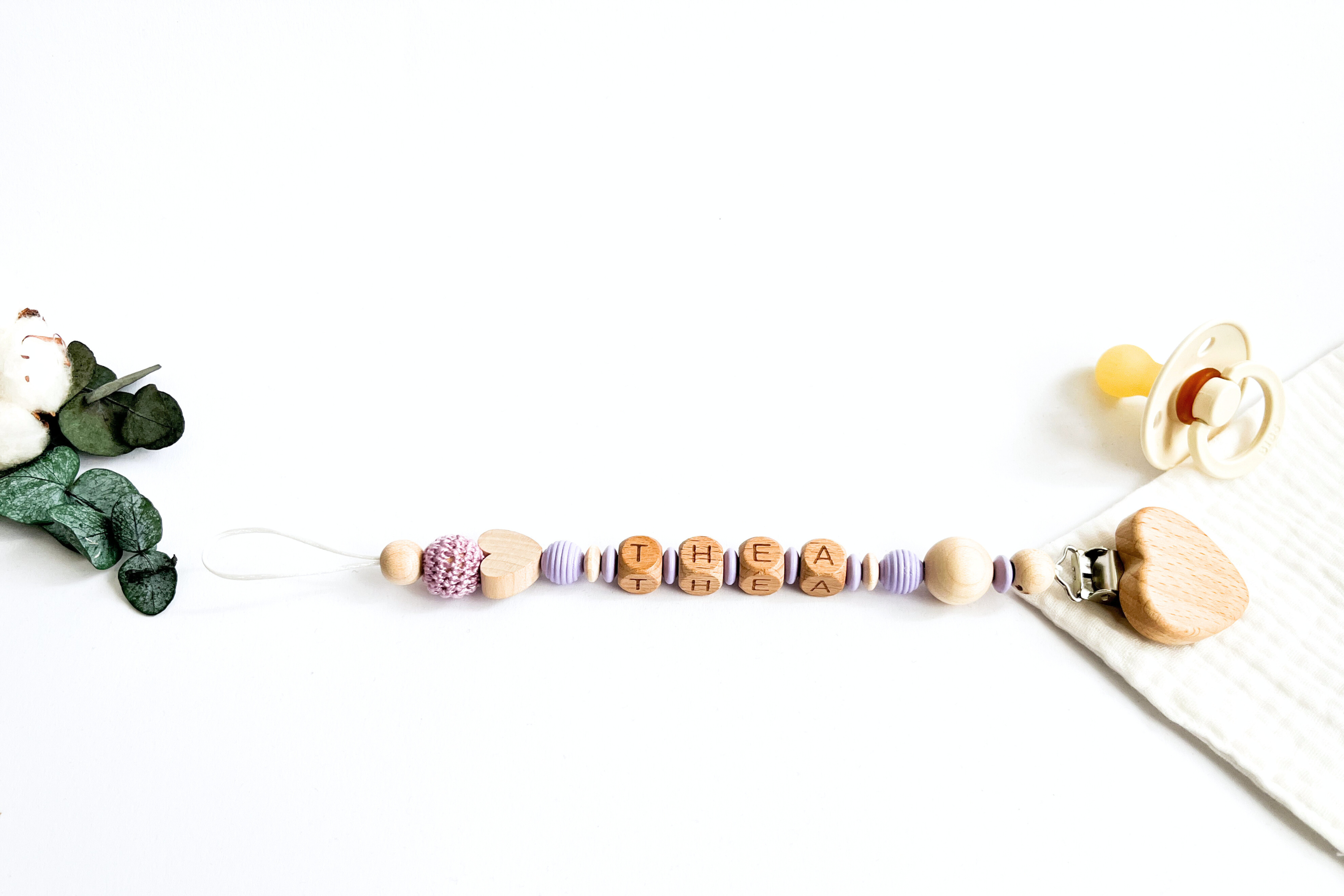 Handgefertigte Schnullerkette aus hochwertigen Materialien mit Clip zur Befestigung an Babykleidung.