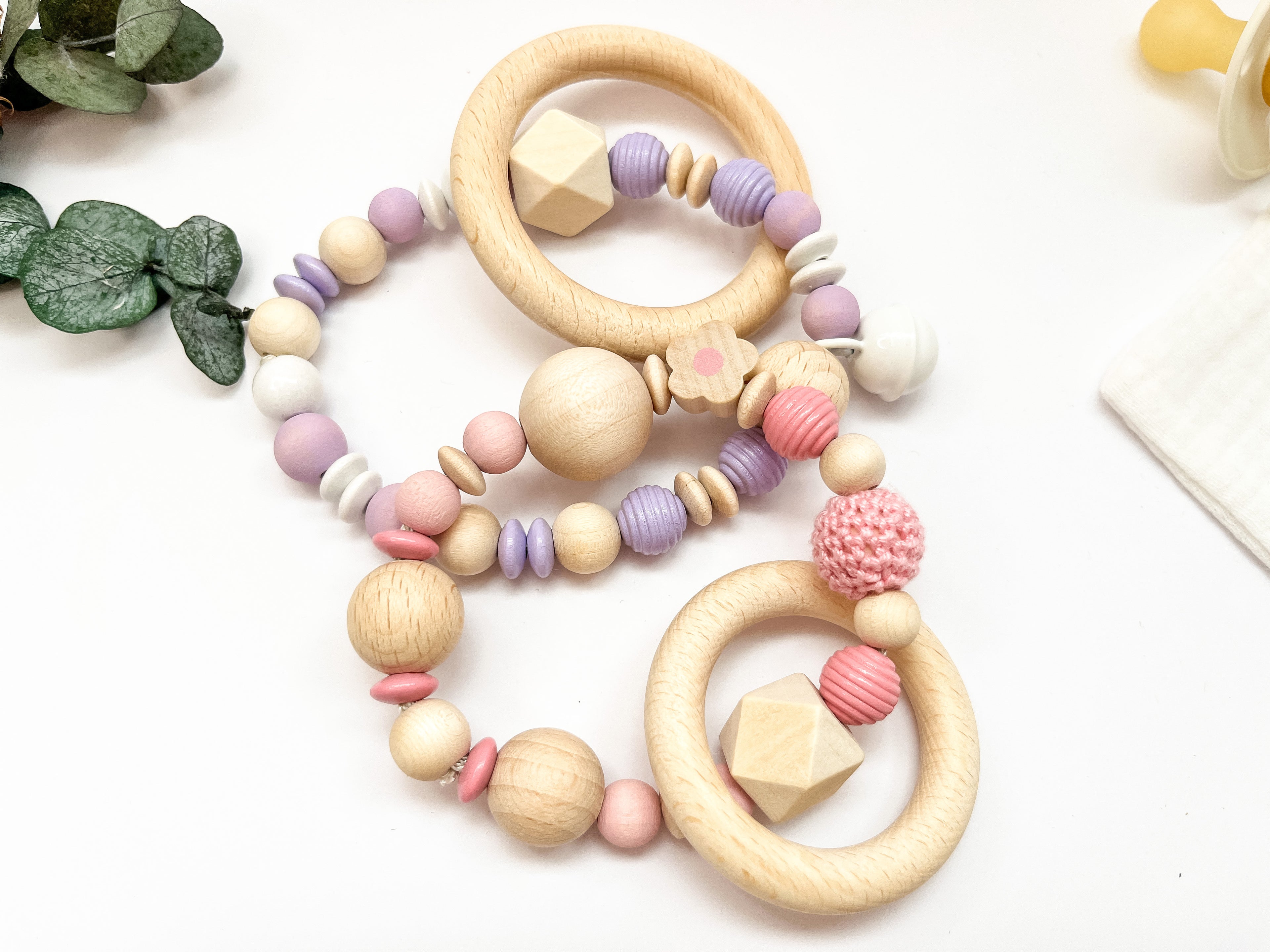 Greifring und Beißring für Babys in verschiedenen Farbvarianten aus Holz und Silikon.